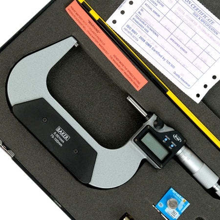 Digital micrometer with a certificate and other documents on a black surface