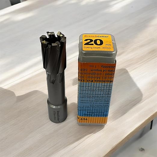 Metal drill bit and packaging on a wooden surface