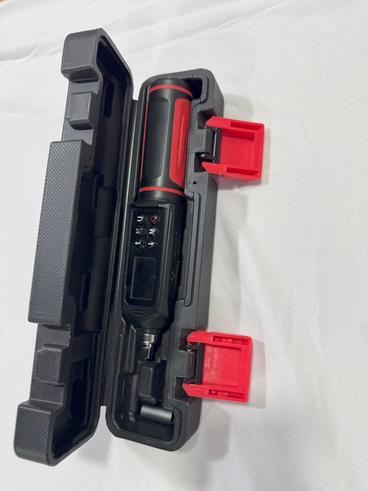 Black and red tool in an open case on a white background